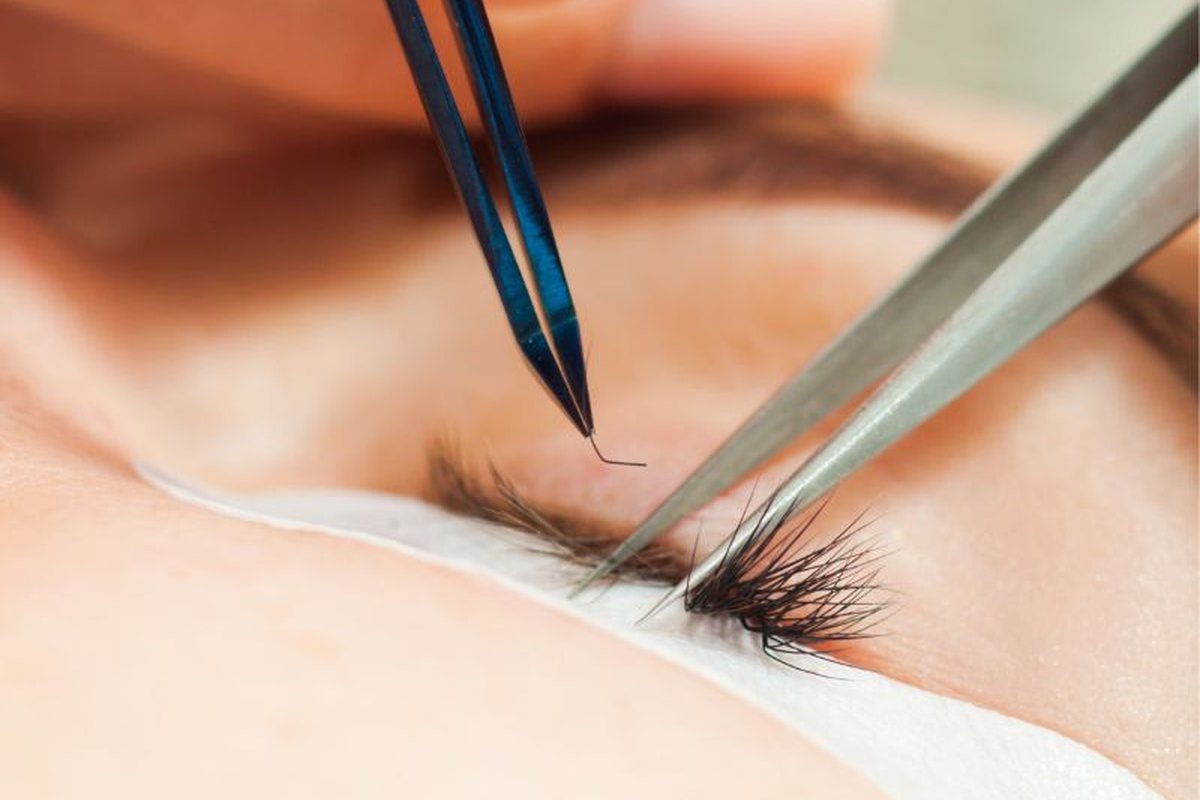 Eyelash extensions being placed one by one with fine tweezers